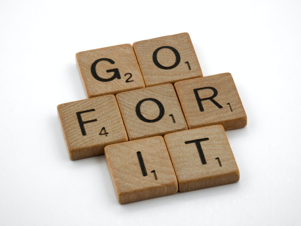 Scrabble Steine die die Worte "Go For It" buchstabieren.